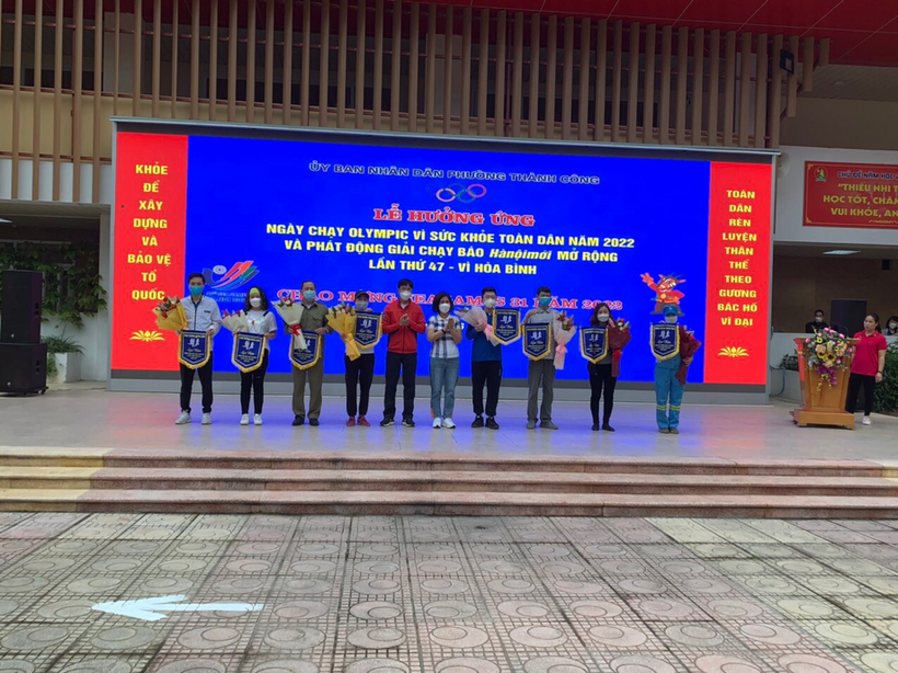 A group of people standing in front of a large screen

Description automatically generated with medium confidence