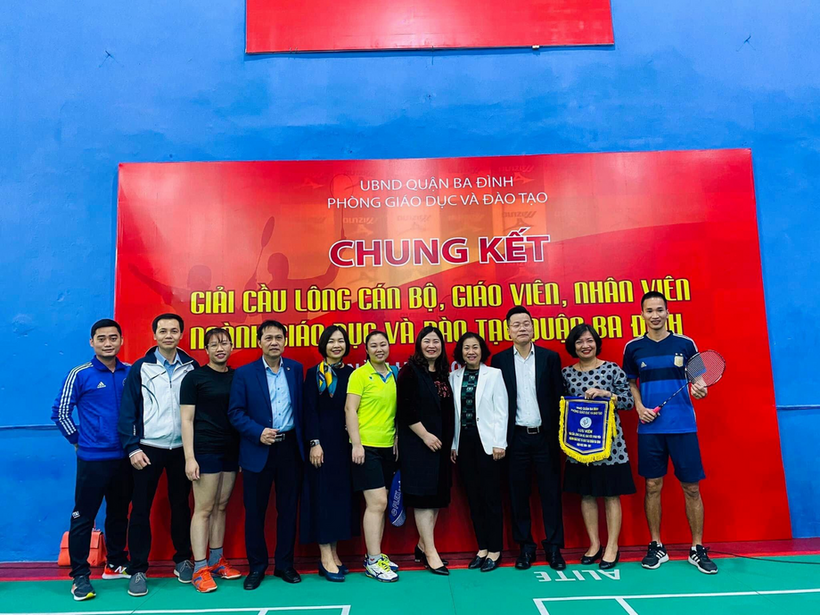 A group of people posing for a photo in front of a sign

Description automatically generated with medium confidence