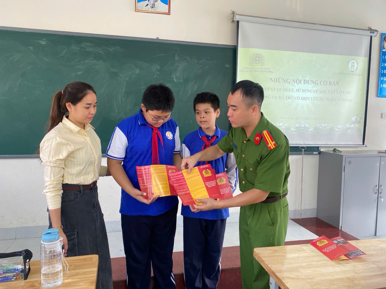 A person holding a book with a group of people in a classroom

Description automatically generated
