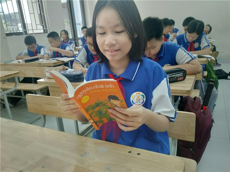 A group of students in a classroom reading a book

Description automatically generated