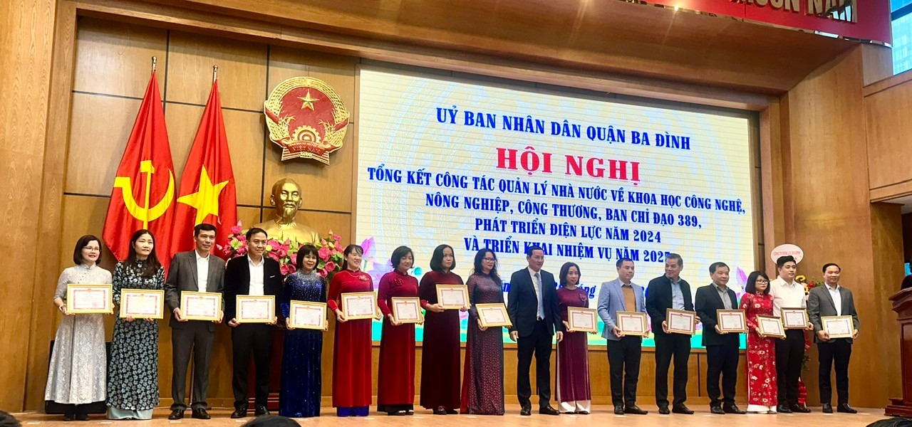 A group of people standing on a stage holding certificates

Description automatically generated