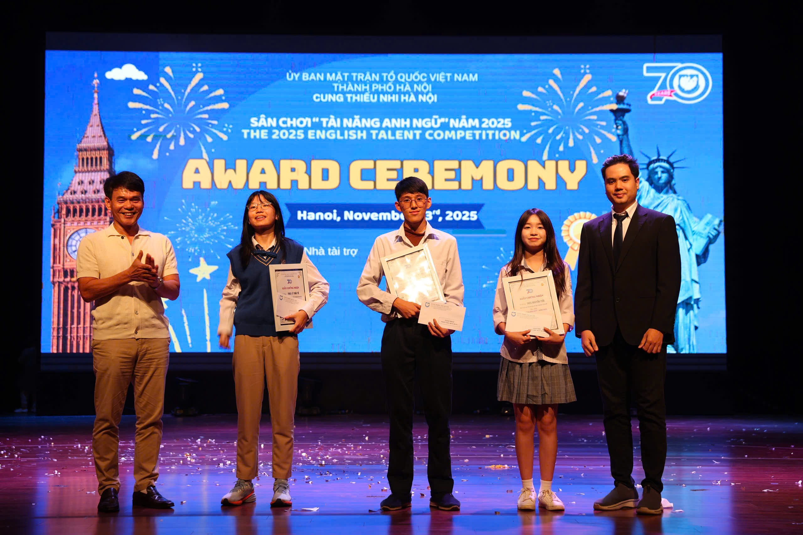 A group of people standing on a stage
Description automatically generated