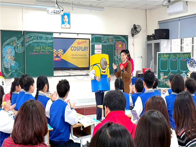 A person in a garment standing in front of a classroom

Description automatically generated
