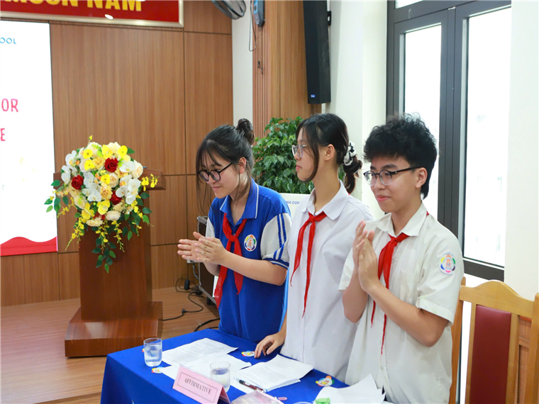 A group of people standing at a table

Description automatically generated