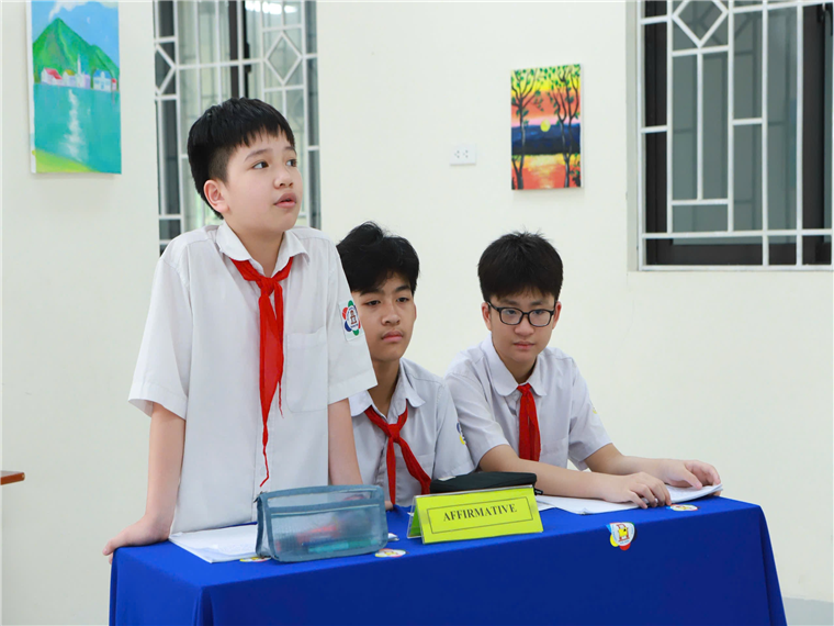 A group of boys in uniform sitting at a table

Description automatically generated