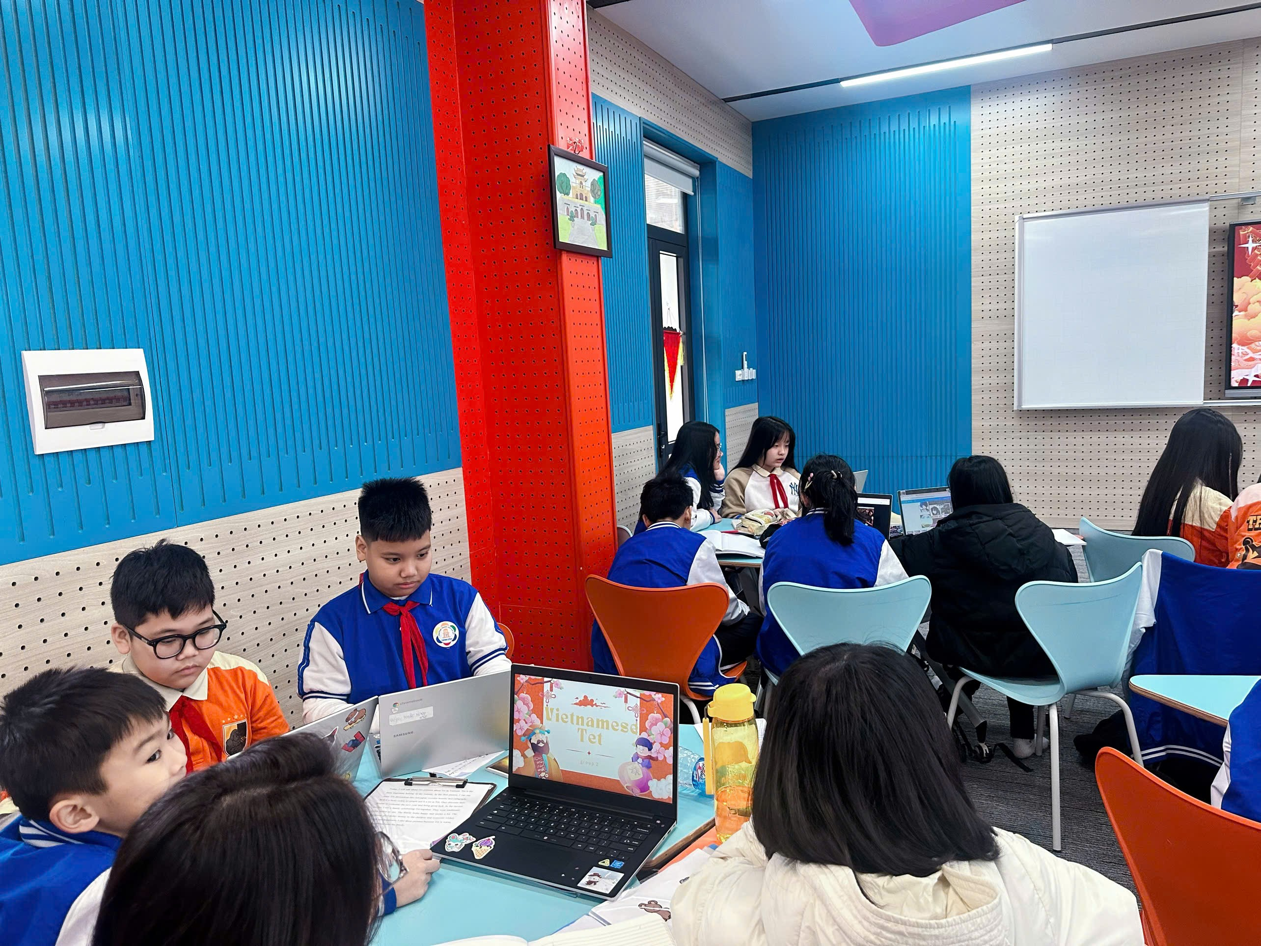 A group of kids sitting at a table with laptops

Description automatically generated