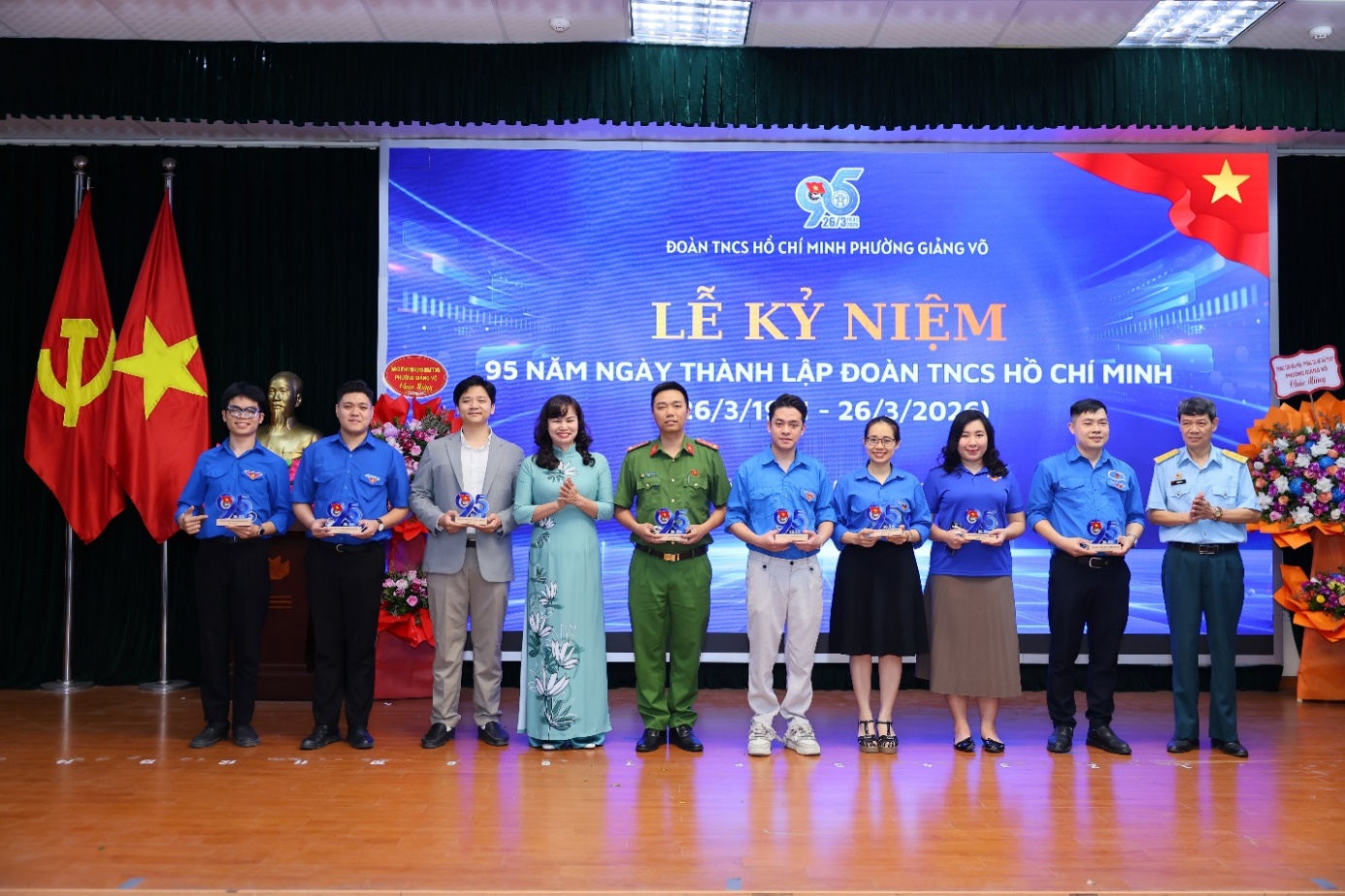 A group of people standing on a stage
Description automatically generated