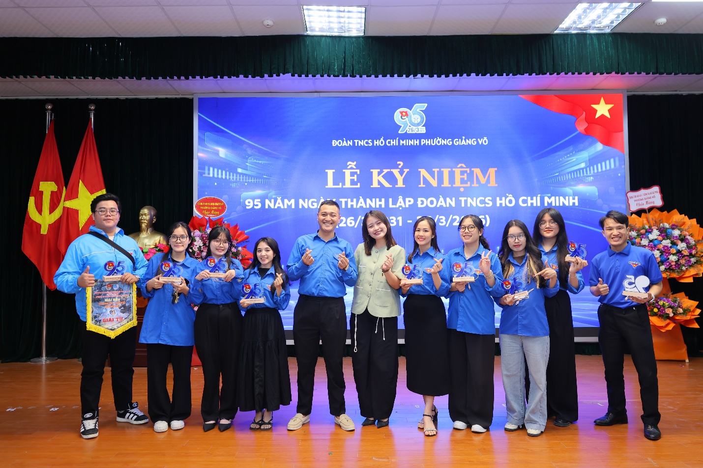 A group of people standing in front of a banner

Description automatically generated