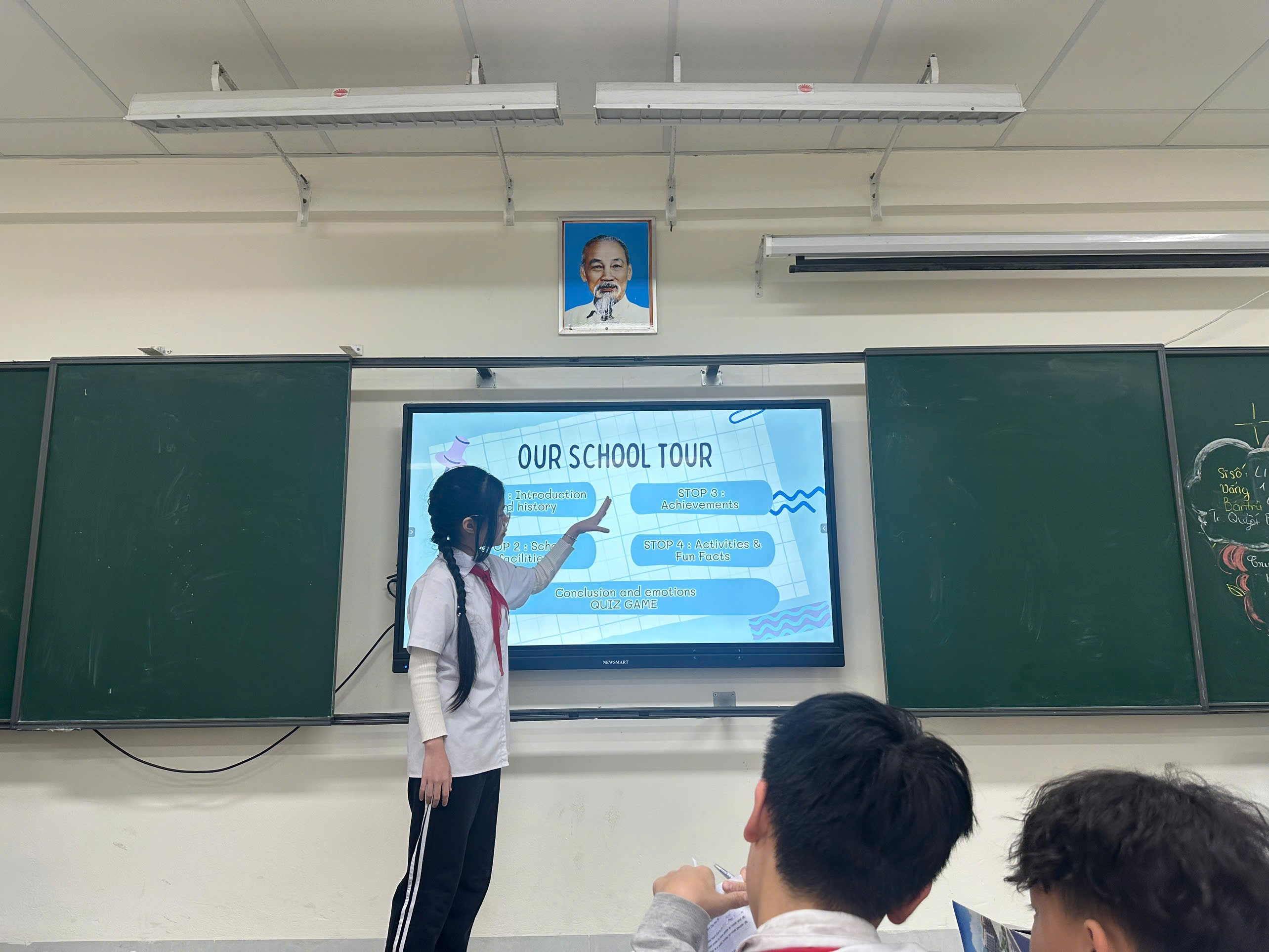 A child pointing at a screen in a classroom

Description automatically generated