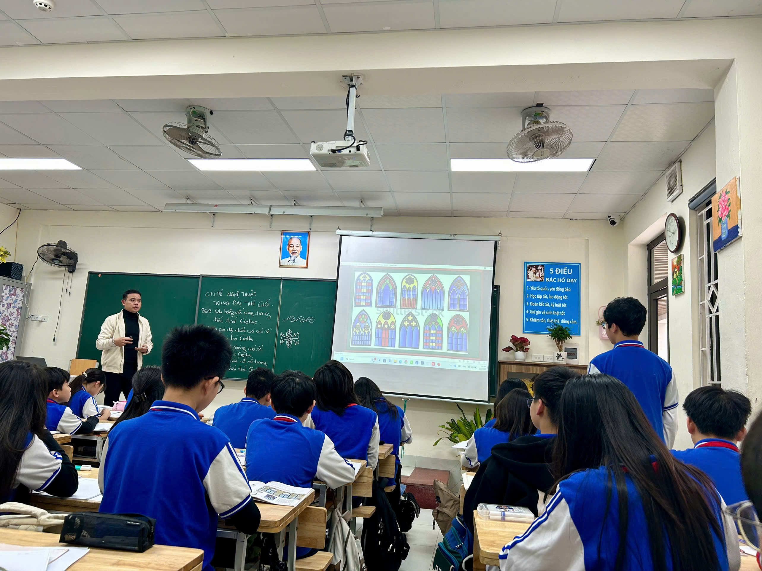 A person standing in front of a classroom

Description automatically generated