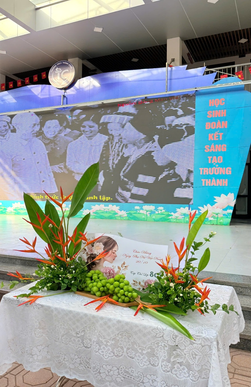 A planter with flowers and a sign

Description automatically generated