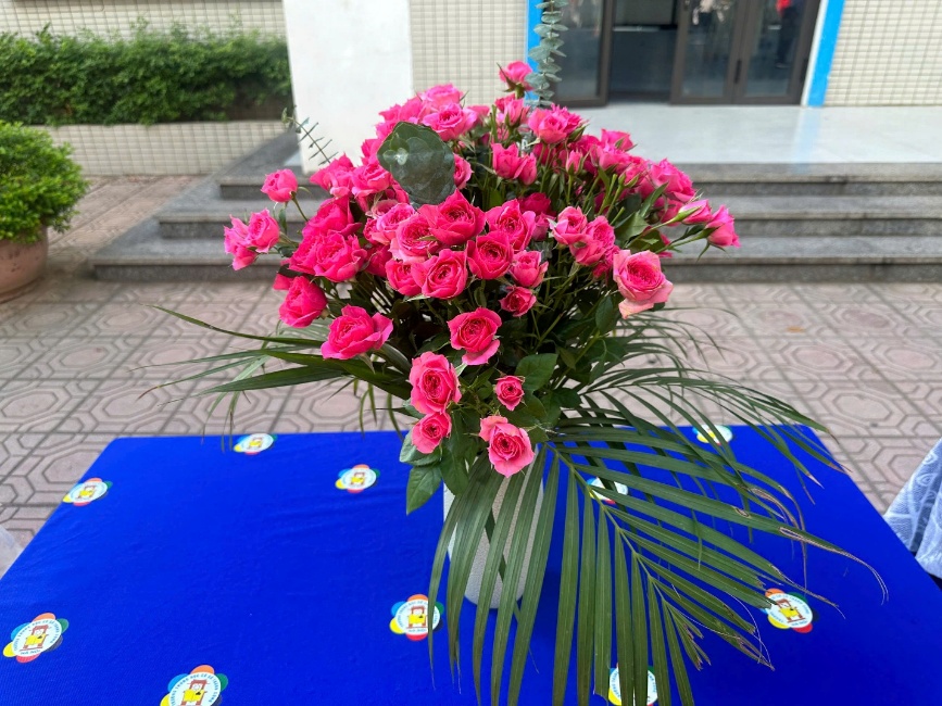 A bouquet of pink roses on a blue table
Description automatically generated