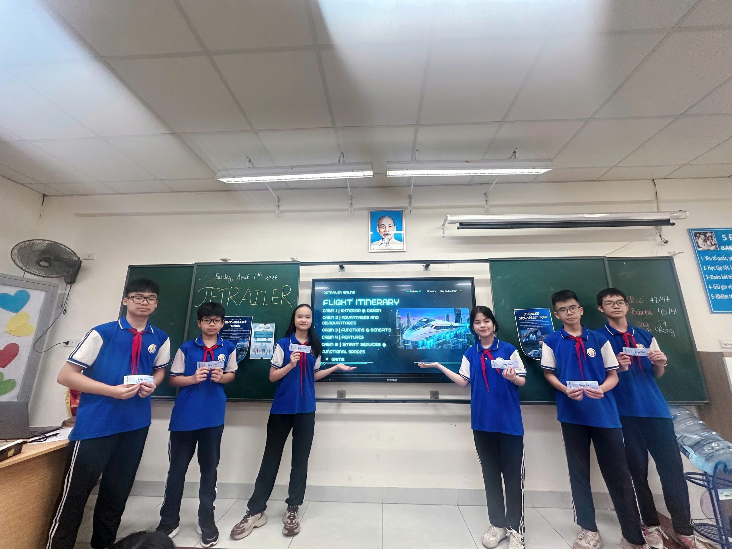 A group of people standing in front of a screen
Description automatically generated