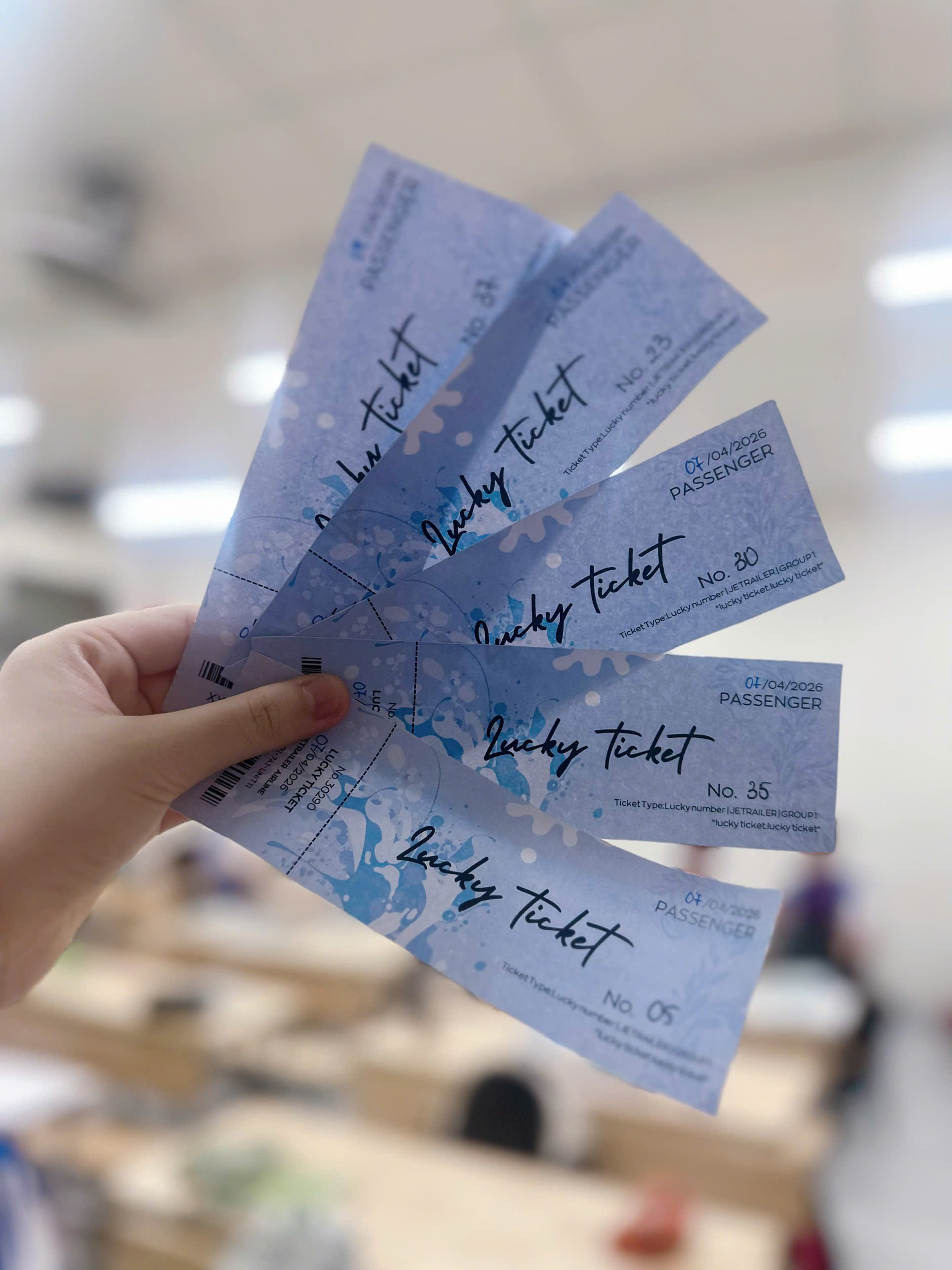 A hand holding a group of tickets
Description automatically generated