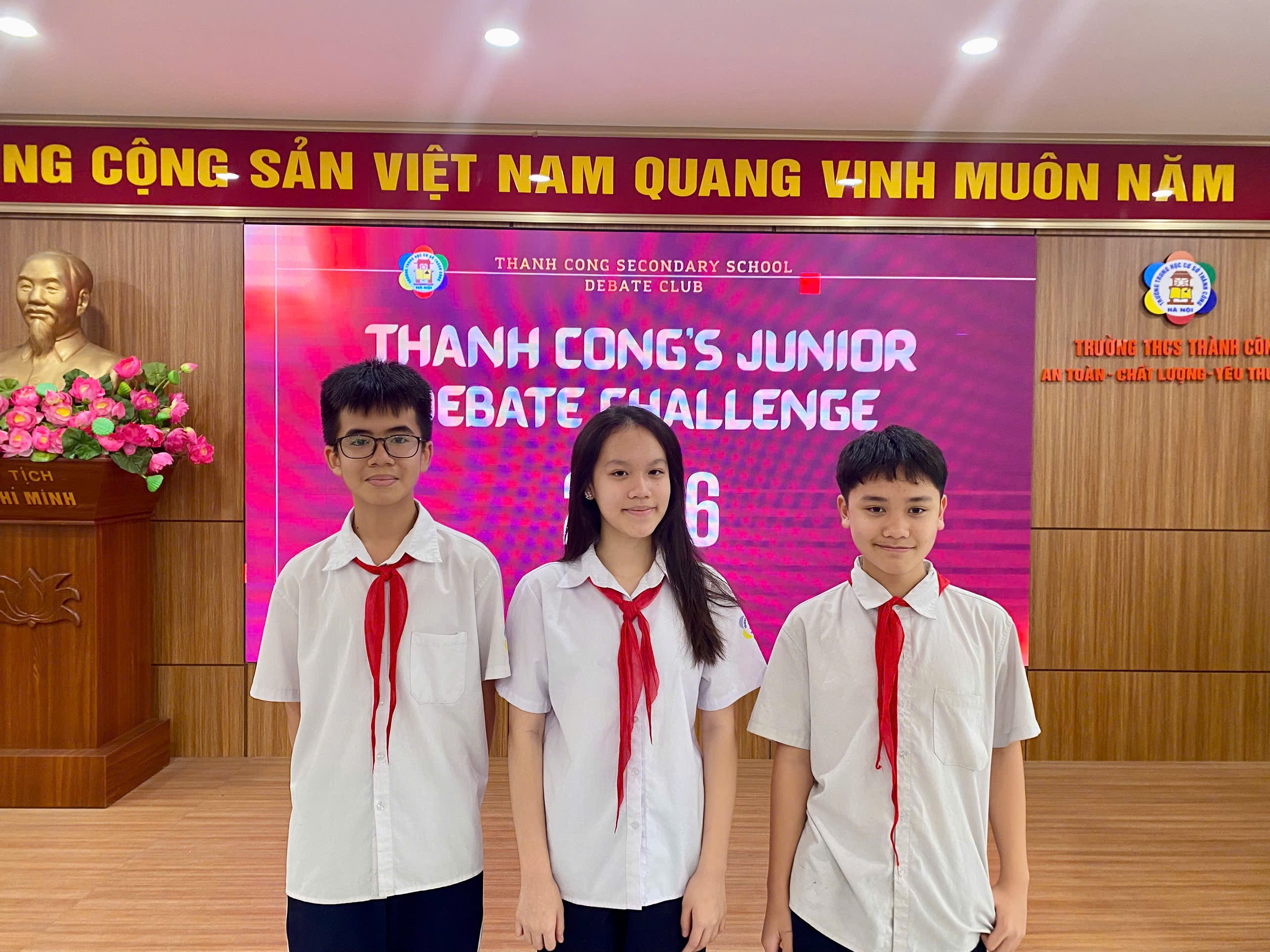 A group of people standing in front of a sign

Description automatically generated